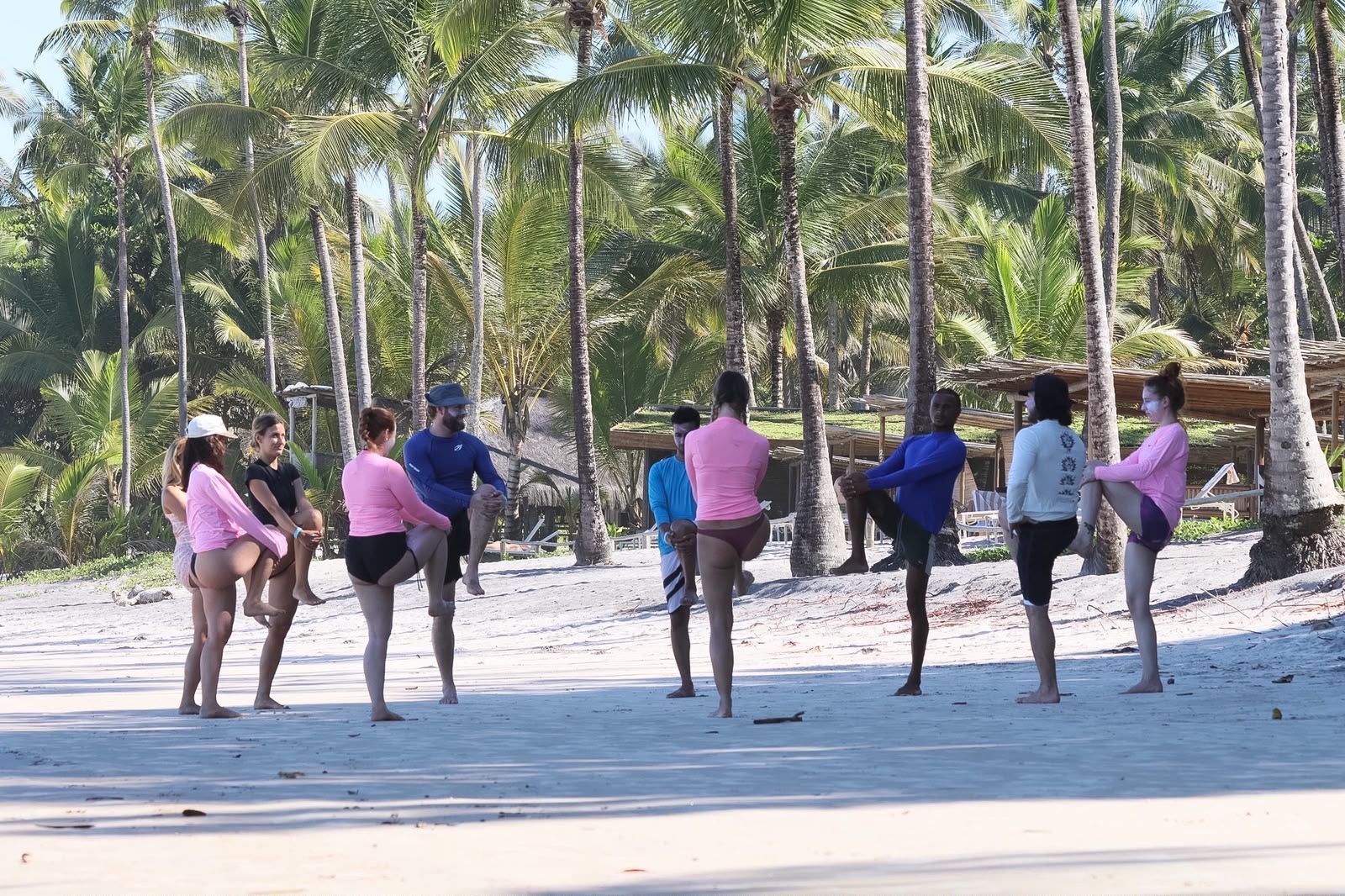 Participantes fazendo alongamento antes da aula de surf